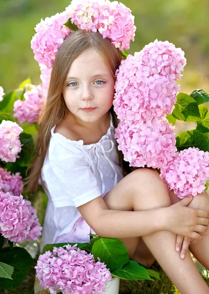 Porträt eines kleinen Mädchens mit Blumen Hortensie — Stockfoto