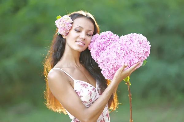 Mooie elegante brunette meisje over de aard — Stockfoto