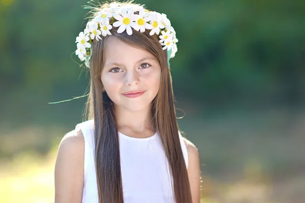 Portret van een mooi klein meisje met bloemen — Stockfoto