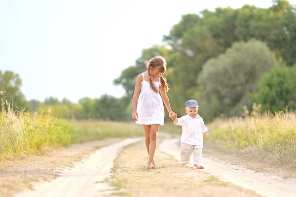 Lilla bror och syster i sommar natur — Stockfoto