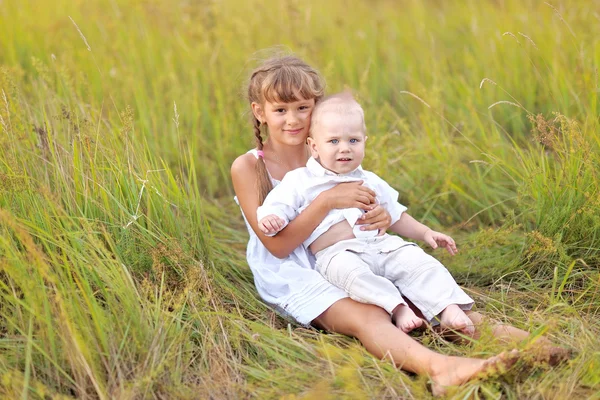 Kleine broer en zus in de zomer natuur — Stockfoto