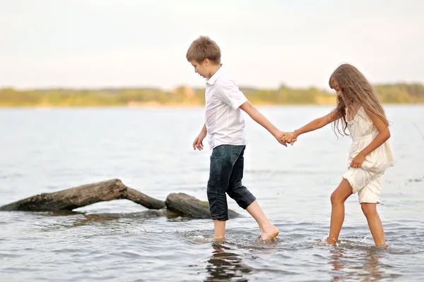 Retrato de um menino e menina brincando na praia — Fotografia de Stock