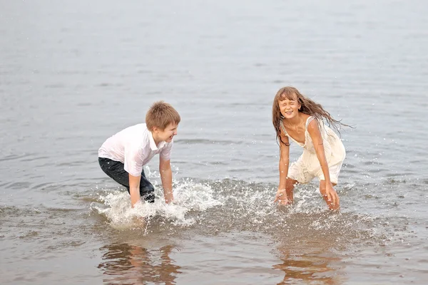 Porträt eines Jungen und eines Mädchens, die am Strand spielen — Stockfoto
