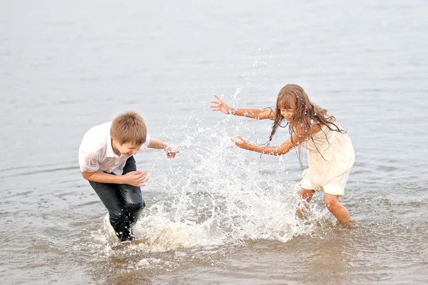Портрет мальчика и девочки, играющих на пляже — стоковое фото