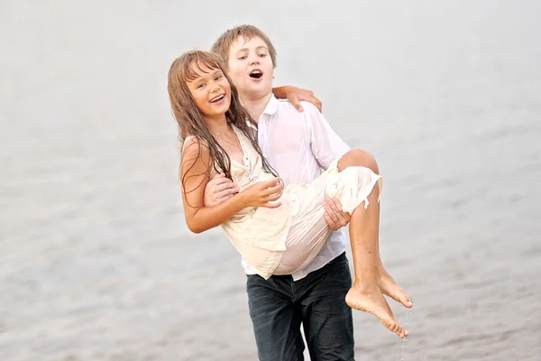 Porträt eines Jungen und eines Mädchens, die am Strand spielen — Stockfoto