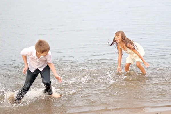 Portrait of a boy and girl playing on the beach — Stock Photo, Image