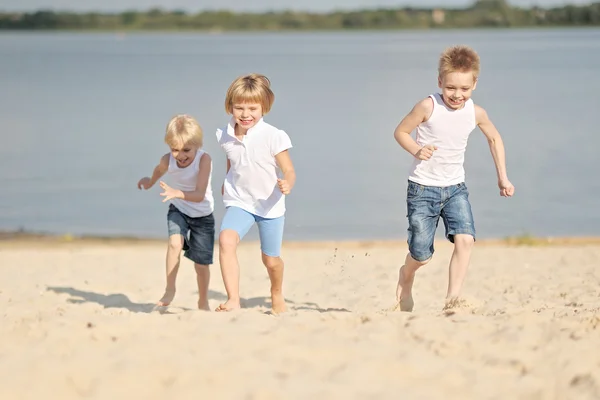 Portret trzech dzieci bawiące się na plaży — Zdjęcie stockowe