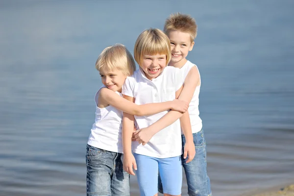 Porträt von drei Kindern, die am Strand spielen — Stockfoto