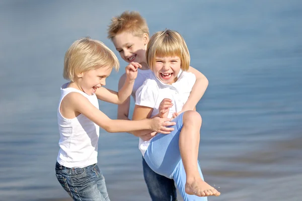 Porträtt av tre barn som leker på stranden — Stockfoto