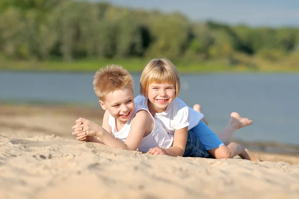 Porträtt av en pojke och flicka på stranden i sommar — Stockfoto