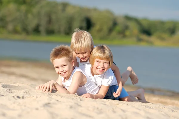 Porträtt av tre barn som leker på stranden — Stockfoto