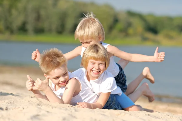 Porträtt av tre barn som leker på stranden — Stockfoto