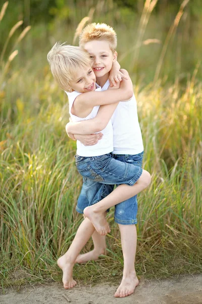 Zwei Kinder spielen im Sommer auf Wiese — Stockfoto