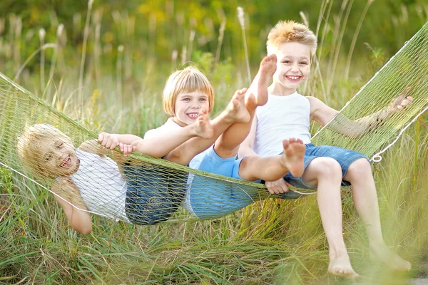 Tre barn leker på ängen i sommar — Stockfoto