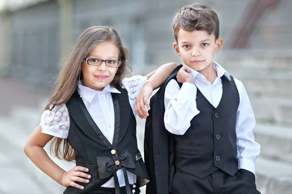 Portrait of a boy and a girl in school suit — Stock Photo, Image