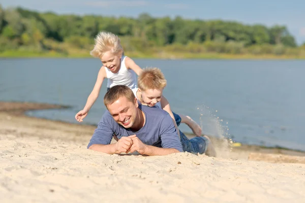 Porträtt av en far och två söner på stranden — Stockfoto