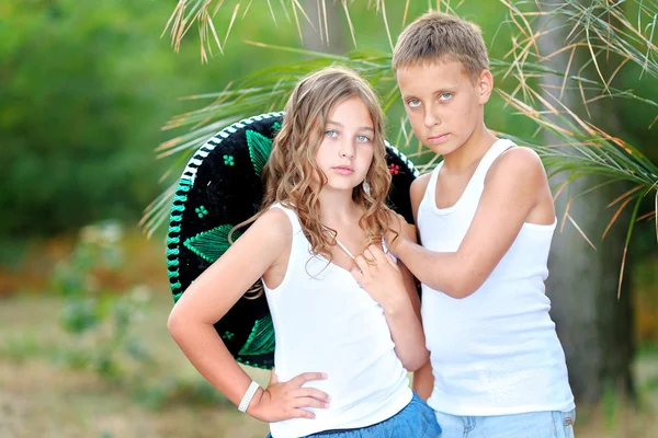 Retrato de un niño y una niña en la playa en verano — Foto de Stock