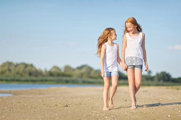 Ritratto di due sorelle che camminano sulla spiaggia — Foto Stock