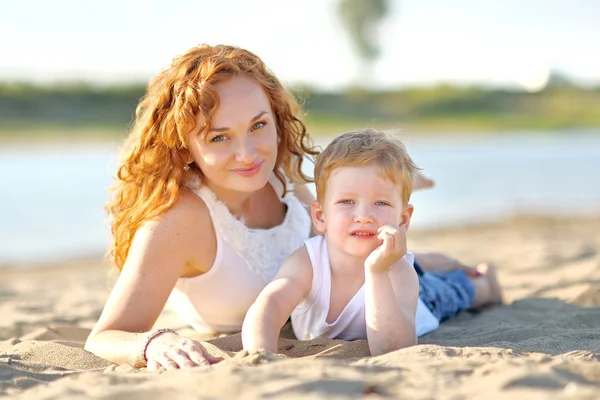 Glad mamma och baby son i sommar natur — Stockfoto