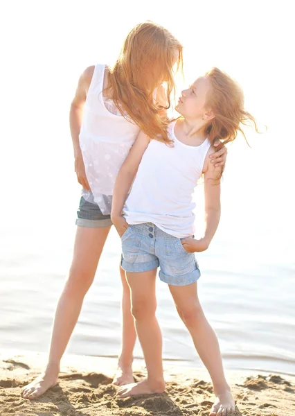 Portrait of two sisters walking on the beach — Stock Photo, Image