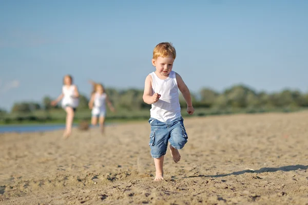 Троє дітей грають на пляжі влітку — стокове фото
