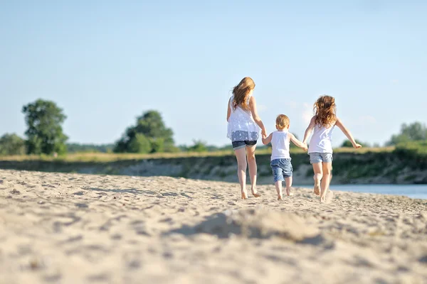 Tre bambini che giocano in spiaggia in estate — Foto Stock