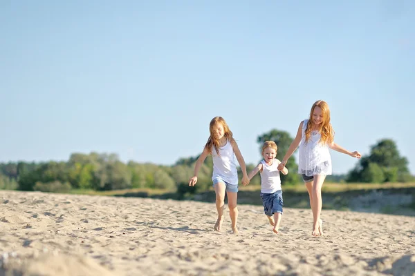 Tres niños jugando en la playa en verano —  Fotos de Stock