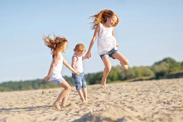 Tre bambini che giocano in spiaggia in estate — Foto Stock