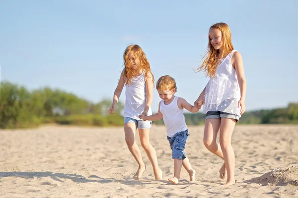Tres niños jugando en la playa en verano —  Fotos de Stock