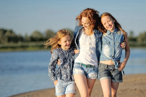 Madre y sus dos hijas en la playa en verano — Foto de Stock