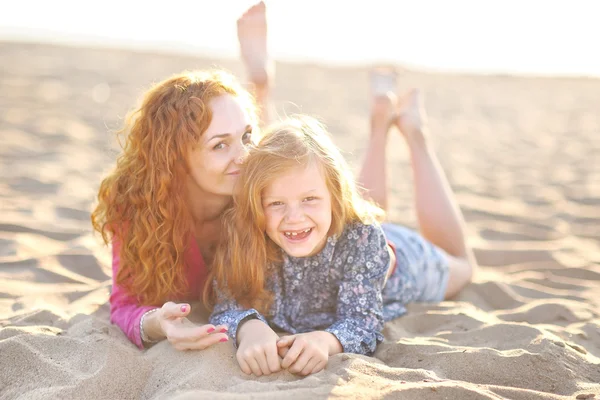 Junge Mutter umarmt ihre Tochter in der sommerlichen Natur — Stockfoto