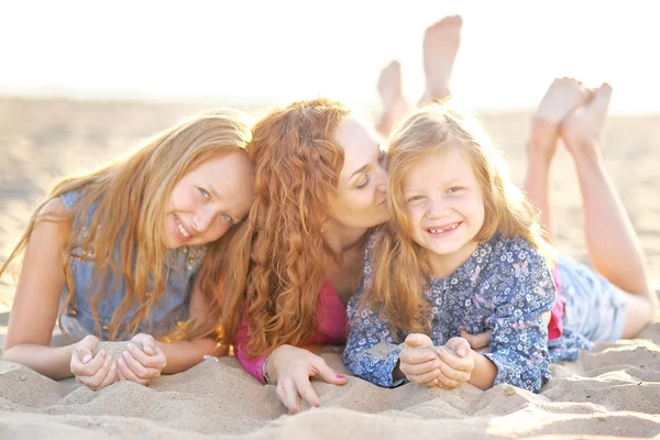 Moeder en haar twee dochters op het strand in de zomer — Stockfoto