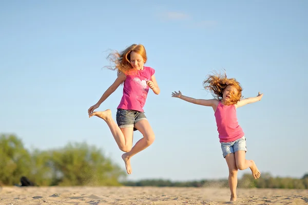 Portret van twee zusters wandelen op het strand — Stockfoto