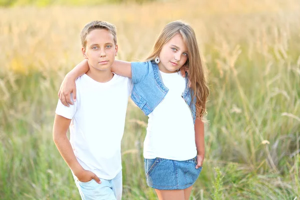 Retrato de um menino e uma menina no campo no verão — Fotografia de Stock