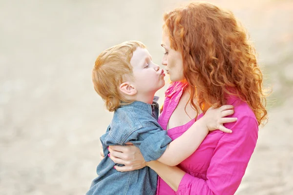 Glad mamma och baby son i sommar natur — Stockfoto