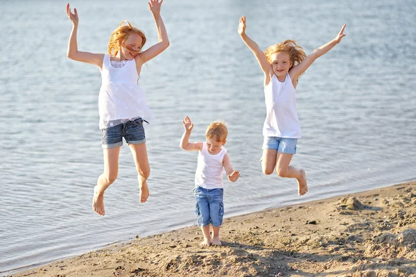 Tre barn som leker på stranden på sommaren — Stockfoto