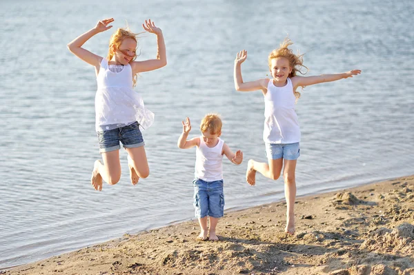Tres niños jugando en la playa en verano — Foto de Stock