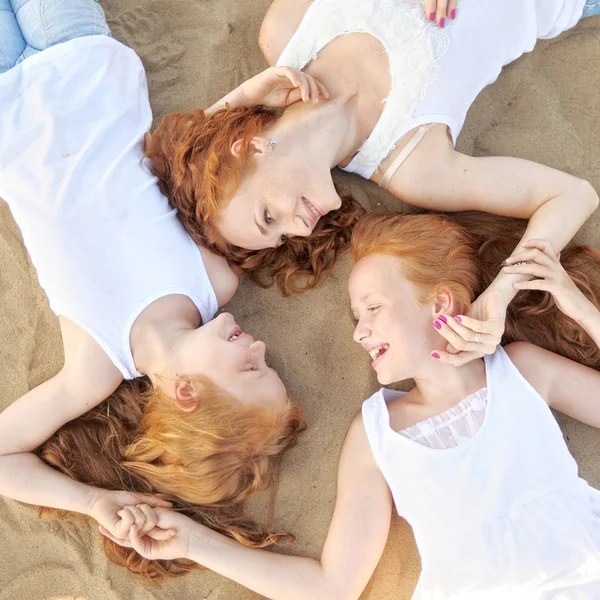 Mutter und ihre beiden Töchter im Sommer am Strand — Stockfoto