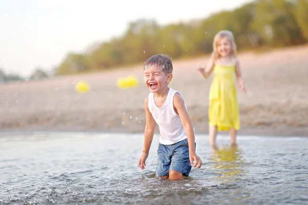 Retrato de um menino e menina na praia no verão — Fotografia de Stock