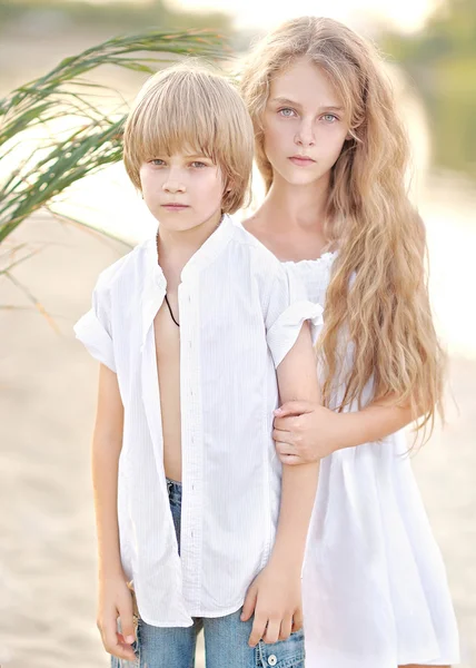 Retrato de um menino e menina na praia no verão — Fotografia de Stock