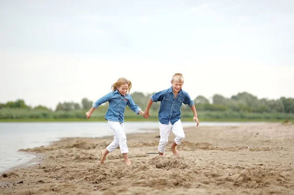 Porträtt av en pojke och flicka på stranden i sommar — Stockfoto