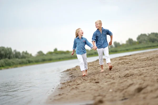 Porträtt av en pojke och flicka på stranden i sommar — Stockfoto