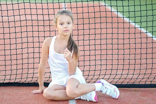Портрет маленькой девочки на теннисном корте — стоковое фото