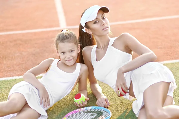 Anne ve kızının tenis kortunda portresi. — Stok fotoğraf