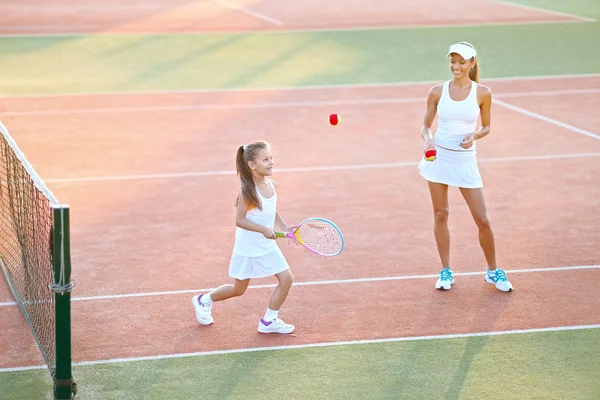 Porträtt av mor och dotter på tennisbanan — Stockfoto