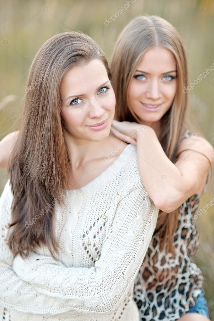 portrait of two beautiful sisters in the autumn