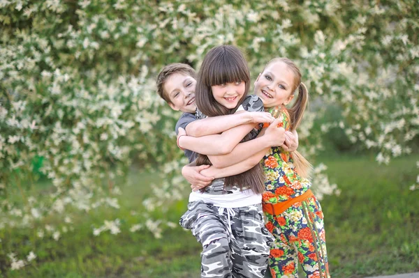 Drie kinderen spelen op weide in de zomer — Stockfoto