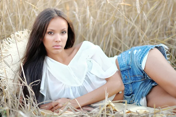 Mooie elegante brunette meisje in een veld — Stockfoto
