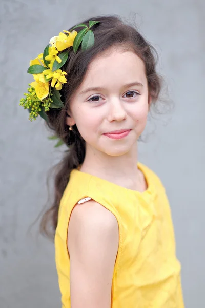 Portret van een mooi klein meisje met bloemen — Stockfoto