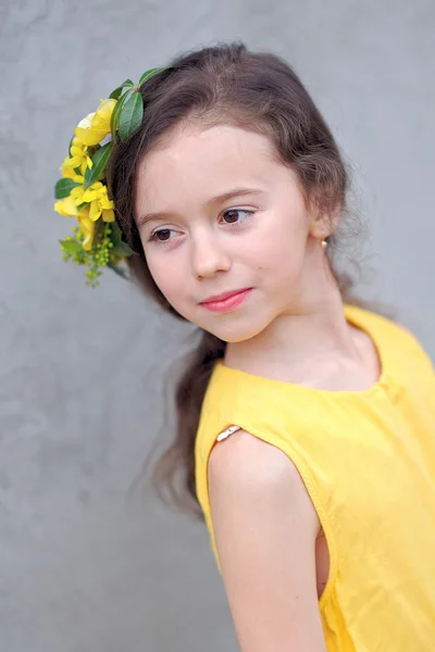 Portret van een mooi klein meisje met bloemen — Stockfoto